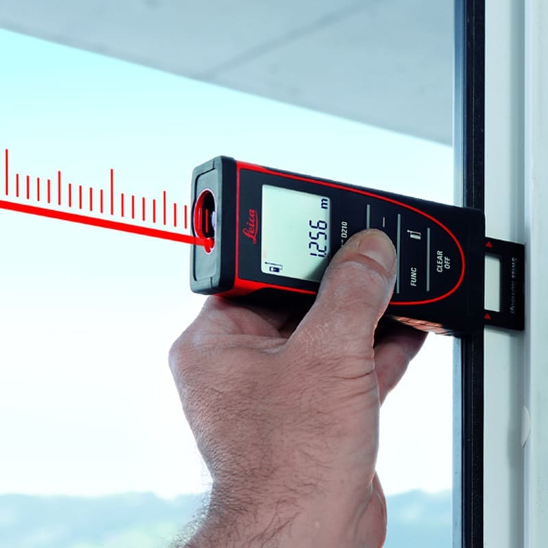 High-precision laser distance measurement device in use on window frame.