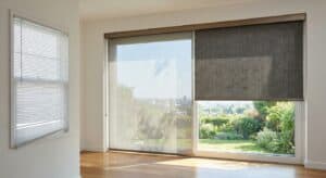 Bright living room with large windows showcasing lush garden view and adjustable window blinds for optimal light control.