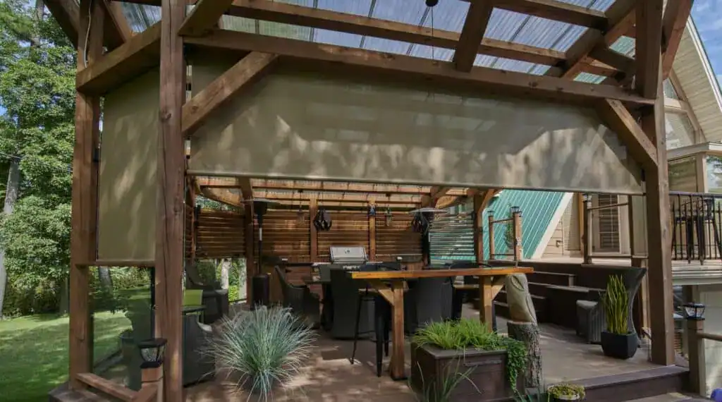 Outdoor wooden deck with seating area, grill, and lush greenery, perfect for relaxing and entertaining in a home backyard.