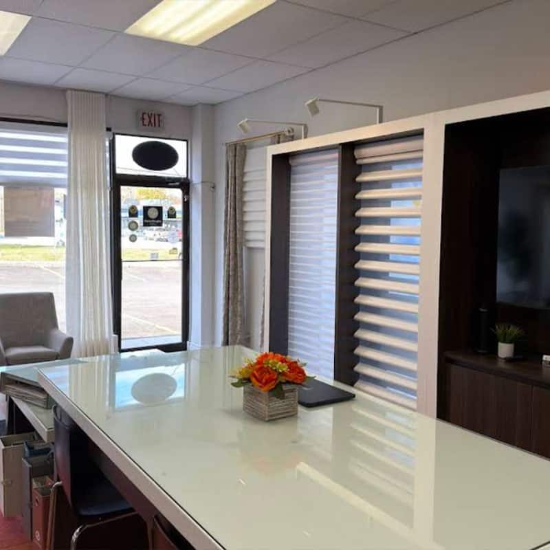 Bright office interior featuring a reception desk, comfortable seating, and decorative plants, creating a welcoming environment for visitors and clients.