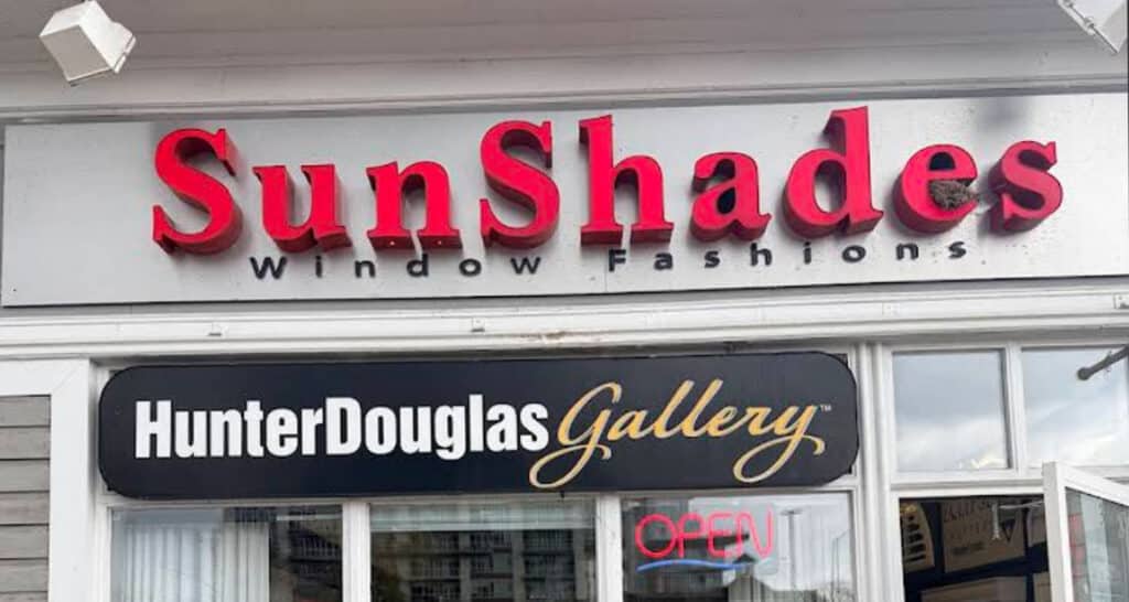 SunShades window fashion store sign with HunterDouglas Gallery logo and open sign, storefront exterior.