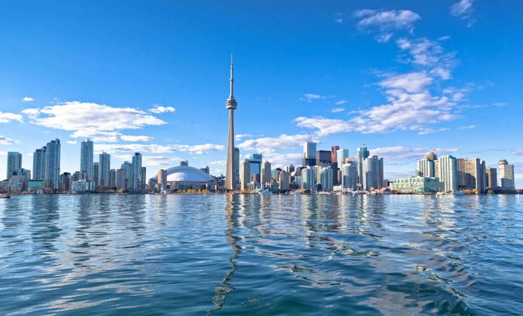 Toronto skyline with CN Tower, high-rise buildings, and waterfront on a clear day.